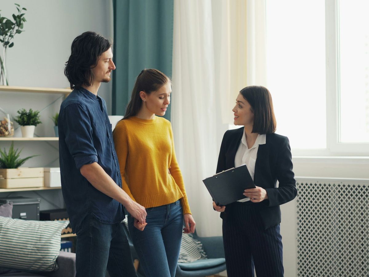 A real estate agent walking a couple through a home